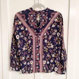 Aina Be floral blouse. Button detail at back of neck. Bell sleeves with ties